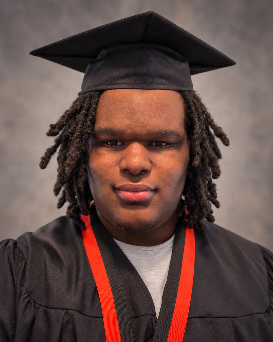 Robert, a PathReady student, in a black graduation cap and gown.